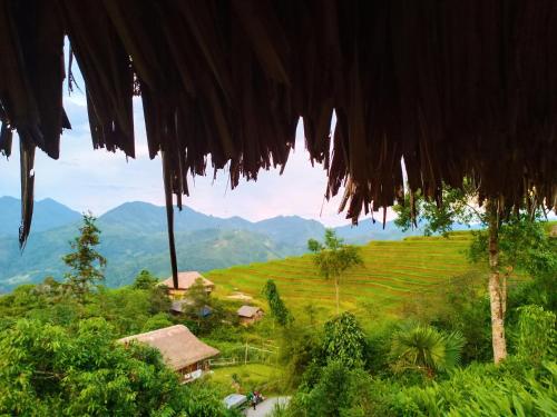 a view from a thatch roof of a village in a field at Dao Homestay in Hoàng Su Phì