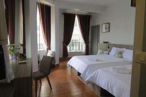 ein Schlafzimmer mit einem Bett und einem Stuhl sowie zwei Fenstern in der Unterkunft 2N Residence in Siem Reap