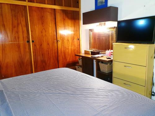 1 dormitorio con 1 cama y vestidor con TV en SOCRA Félix Bogado CASA ENTERA PARA 7 PERSONAS, en Asunción