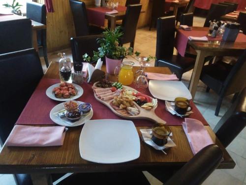 a wooden table with plates of food on it at Vila Dracula in Căpăţîneni-Pămînteni