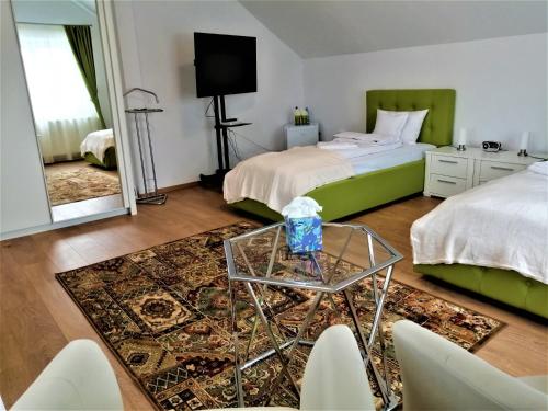 1 Schlafzimmer mit 2 Betten und einem Glastisch in der Unterkunft Tudor Central House Sibiu in Sibiu