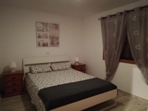 1 dormitorio con 1 cama, 2 mesitas de noche y ventana en Calle Hesperides en Costa Del Silencio