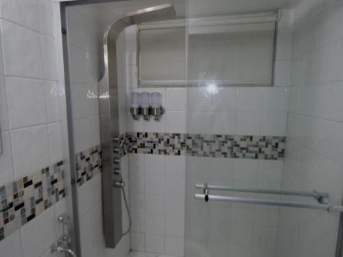 a shower with a glass door in a bathroom at SERENADE Lodging Rooms in Panama City