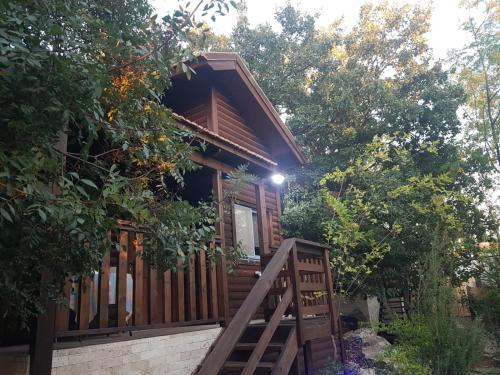 a cabin in the woods with a wooden porch at Mazal shell Zimmer in Amirim