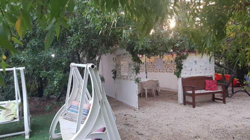 a swing set in a backyard with a tree at Mazal shell Zimmer in Amirim