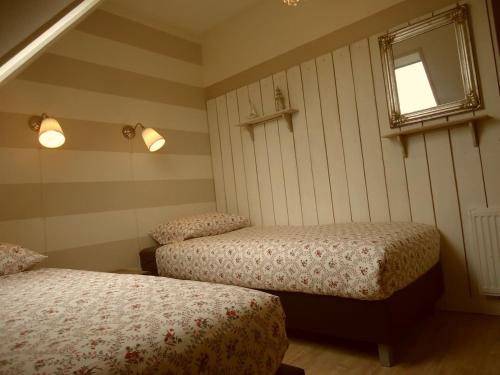 מיטה או מיטות בחדר ב-Ferienhaus Zeeduinsepoort