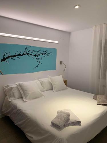 a white bed with two towels on top of it at La Pomera in Vilaller