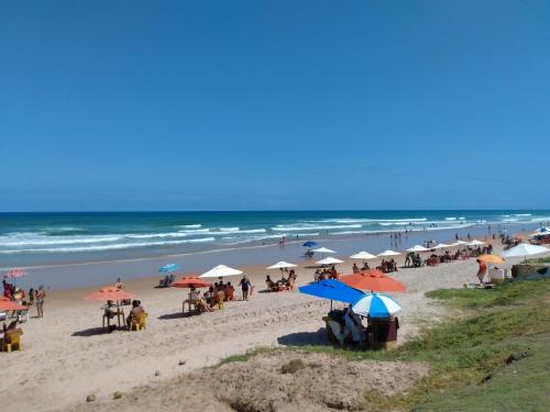 a group of people sitting on a beach with umbrellas at Apartamento em frente Mar in Salvador