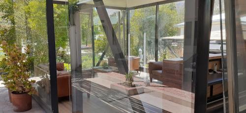 a conservatory with glass doors and plants in it at Hotel El Milagro in Pisco Elqui