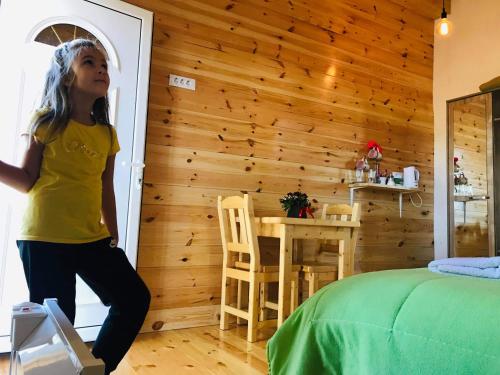 a little girl standing in a bedroom with a bed at Organic Family Farm in Žabljak