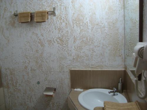 La salle de bains est pourvue d'un lavabo blanc et de toilettes. dans l'établissement VIS PENSION, à Viile Satu Mare