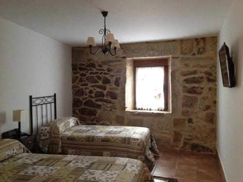 a bedroom with two beds and a window at Alojamiento Pazos in Cea