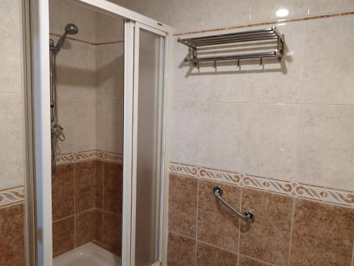 La salle de bains est pourvue d'une douche avec une porte en verre. dans l'établissement Precioso apartamento en el Arenal, à Séville