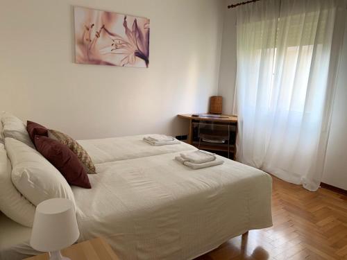 a white bed in a room with a window at Sweet Home in Trieste