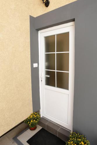 a white door on the side of a building with flowers at Radman's house in Niš