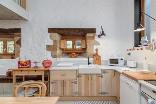a kitchen with wooden cabinets and a sink at Las Azadas in Tezanos