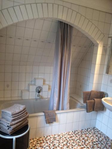 a bathroom with a tub and a sink and a mirror at Hus Nordhauk in Borkum