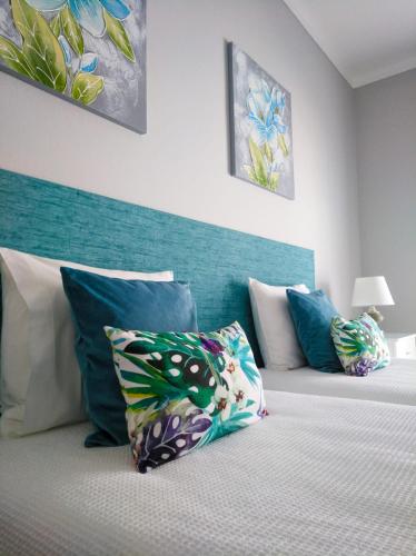 a bedroom with a bed with a blue headboard and pillows at Casa Vaz in Grândola