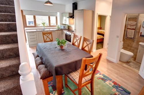 eine Küche und ein Esszimmer mit Tisch und Stühlen in der Unterkunft Roman Height's Holiday Cottages in Haltwhistle