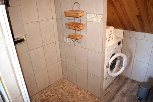 a small bathroom with a washing machine and a washer at La mare aux Canards, 8mn du Zoo de Beauval in Châteauvieux