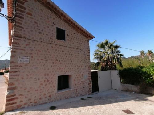 a brick building with a white door and a palm tree at Villa Can Batach-Nueva Construcción en Sóller in Sóller