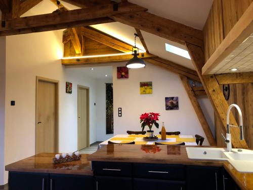 a kitchen with wooden ceilings and a kitchen island with a sink at La Datcha du Parc in Husseren-Wesserling