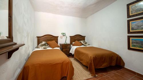 two beds in a room with two beds sidx sidx sidx sidx at Casas rurales de Guayadeque in Ingenio