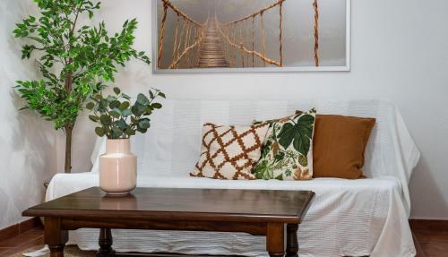 a white couch with pillows and a vase on a table at Casas rurales de Guayadeque in Ingenio