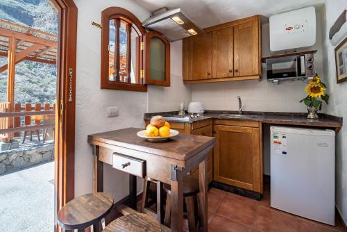 a kitchen with a table with a bowl of fruit on it at Casas rurales de Guayadeque in Ingenio