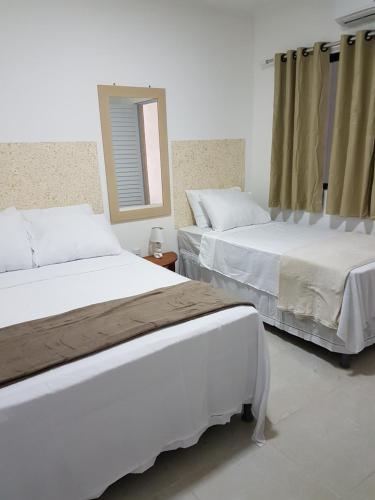 Un ou plusieurs lits dans un hébergement de l'établissement Residencial e Pousada Sea La Vie