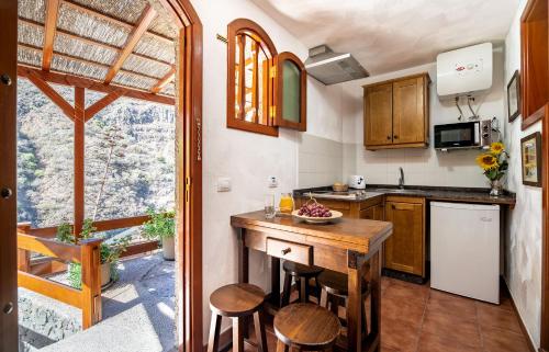a kitchen with wooden cabinets and a counter with stools at Casas rurales de Guayadeque in Ingenio