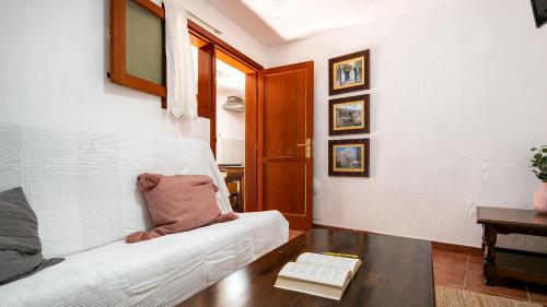 a living room with a white couch and a table at Casas rurales de Guayadeque in Ingenio