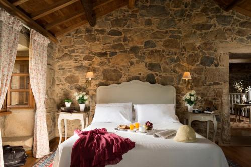 a bedroom with a bed with a stone wall at A Casa da Torre Branca in Santiago de Compostela