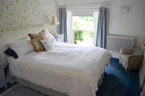 a bedroom with a white bed and a window at Stroud House in Freshwater