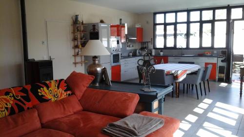 un salon avec un canapé et une table et une cuisine dans l'établissement L atelier, à Casteljaloux
