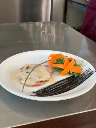a plate of food with carrots on a table at Villa Liliana in Cervia
