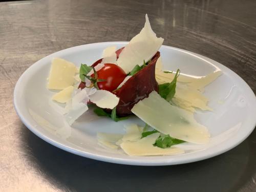 a plate of food with cheese and tomatoes on a table at Villa Liliana in Cervia
