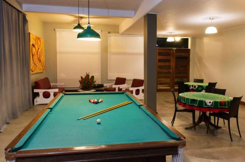 
a room with a table, chairs, and a pool table at Hotel Porto Di Mare in Ubatuba
