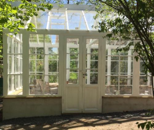 an or greenhouse with a door and windows at Peaceful, Picturesque Lake & Forest Retreat in Stockholm