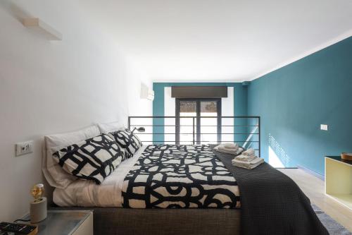 - une chambre avec un lit et un mur bleu dans l'établissement Paki Home nel cuore dei navigli di Milano, à Milan
