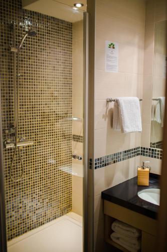 a bathroom with a glass shower and a sink at Neva Apartment Angella Konaci in Kopaonik