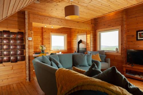 un soggiorno con divano blu e TV di Sundown Cottages a Leurbost