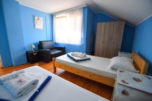 a small room with two beds and a chair at Nana Tekija in Tekija