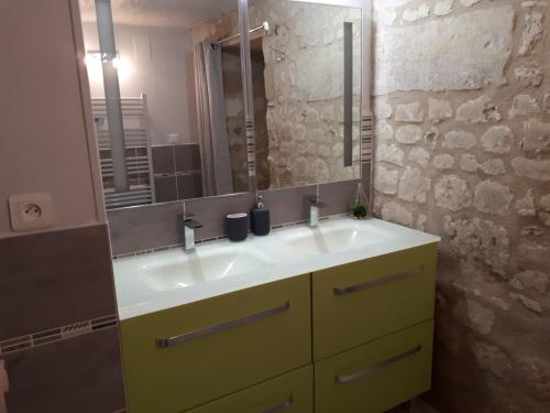 a bathroom with a yellow sink and a mirror at Petit havre de tranquillité in Loudun