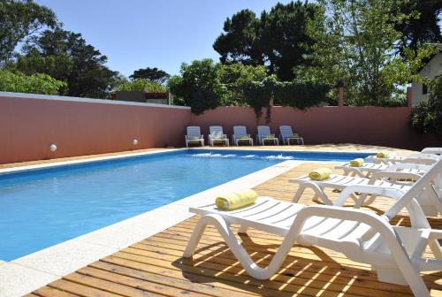 a pool with lounge chairs and a swimming pool at LA AGUADA - Villa de Mar in Villa Gesell