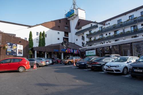 a parking lot with cars parked in front of a building at Apartament 902 Alpin Resort Poiana Brasov in Poiana Brasov
