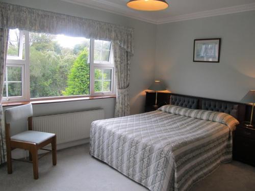 a bedroom with a bed and a large window at Neidin House in Kenmare