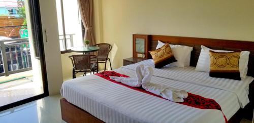 a bedroom with a large bed with white sheets at KANPAI HOTEL in Patong Beach