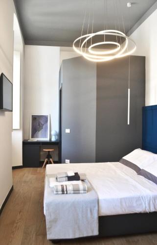 a bedroom with a large white bed and a chandelier at Da Domè Charm Rooms in Levanto