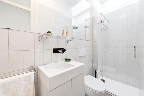 a white bathroom with a sink and a toilet at Casa do Sapalinho II - Setubal Downtown in Setúbal